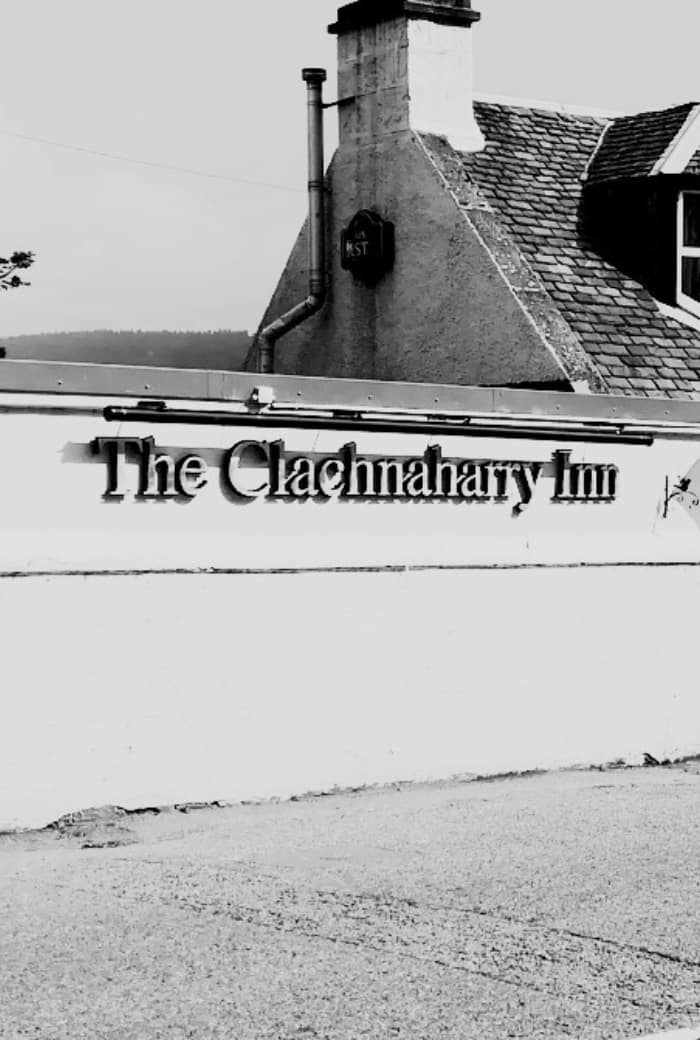 Black and white photo of The Clachnaharry Inn signage, with the name in bold lettering mounted on the exterior wall of the historic Inverness pub, symbolizing its longstanding presence since 1700.